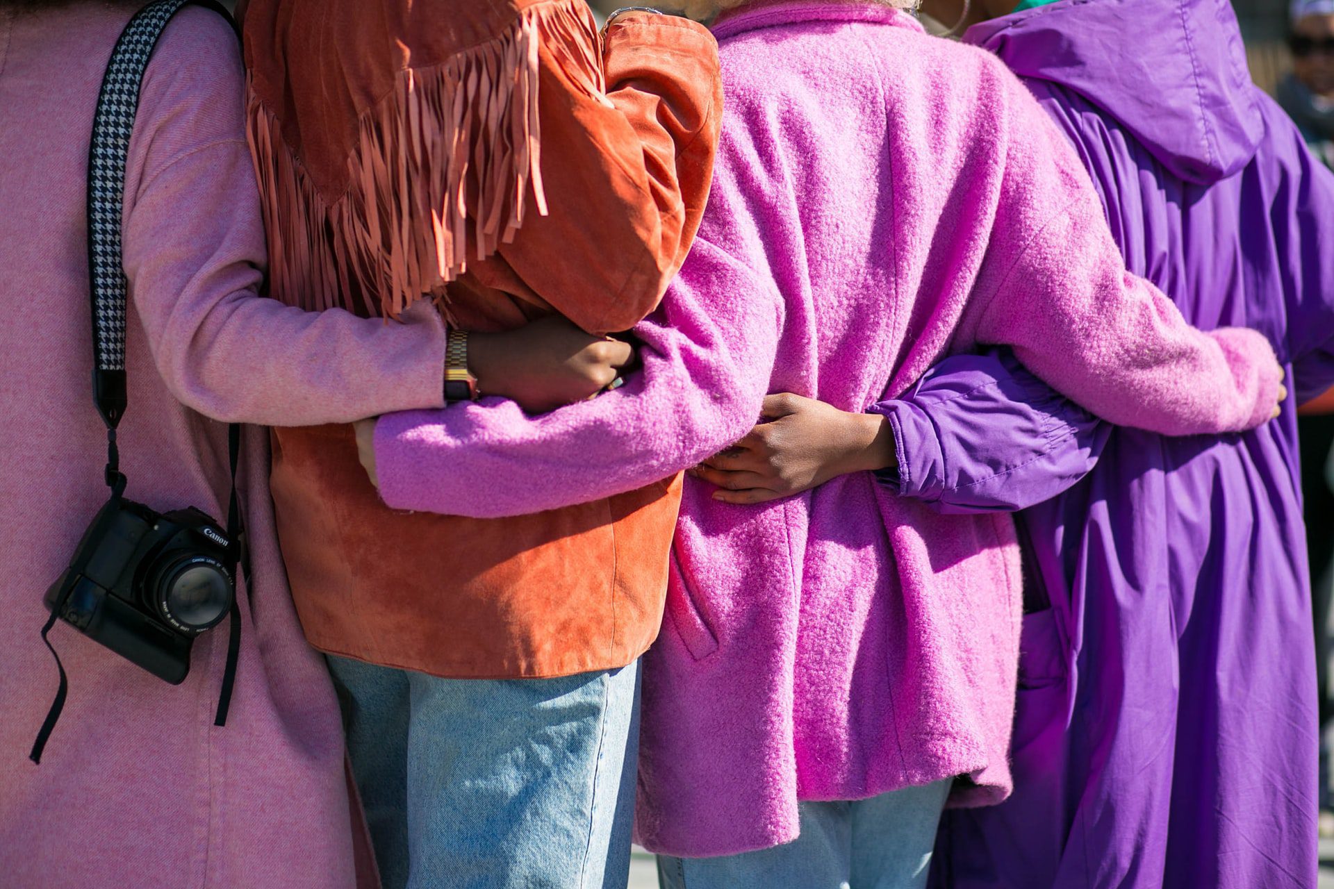 The backs of four women in colorful jackets